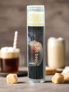 Clear cylindrical container with 'root beer' label on a wooden surface with drinks in the background