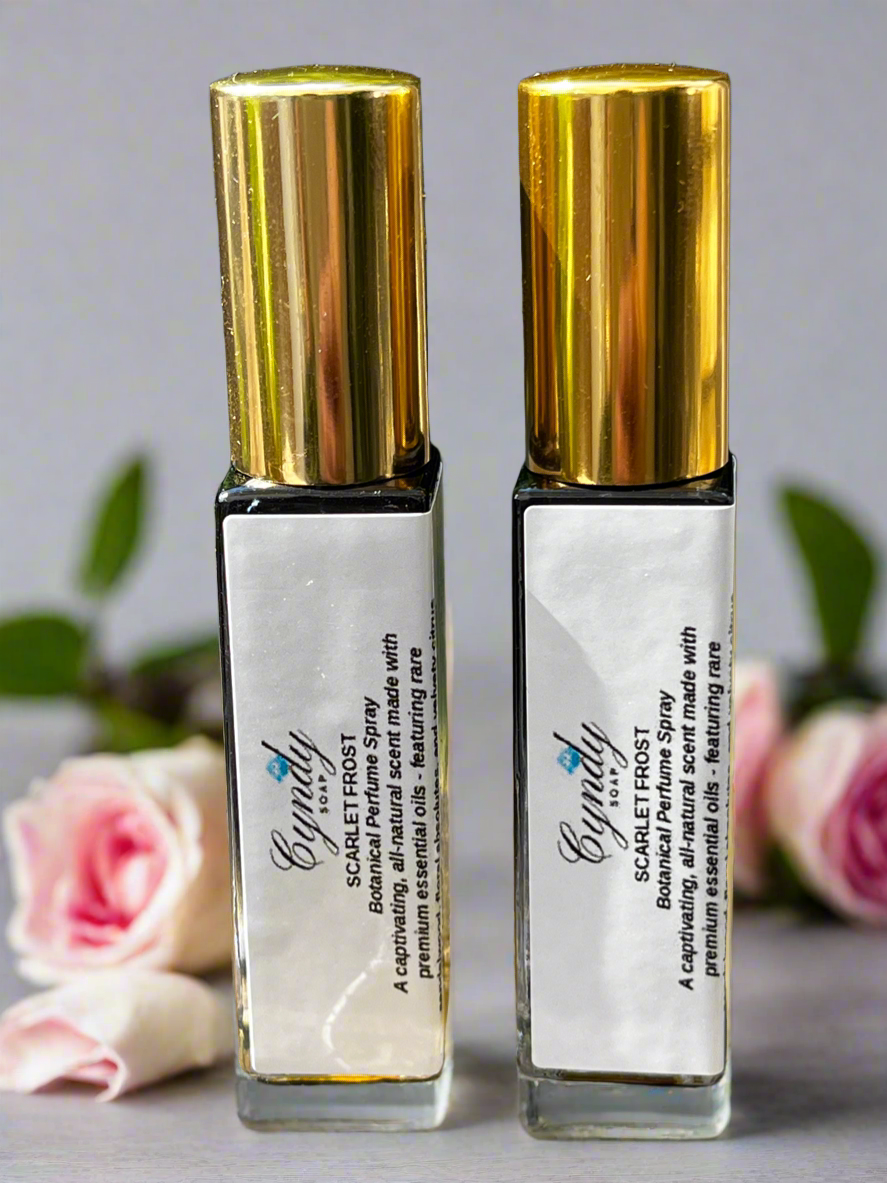 Scarlet Frost Botanical Perfume Spray surrounded by roses