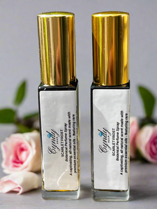 Scarlet Frost Botanical Perfume Spray surrounded by roses