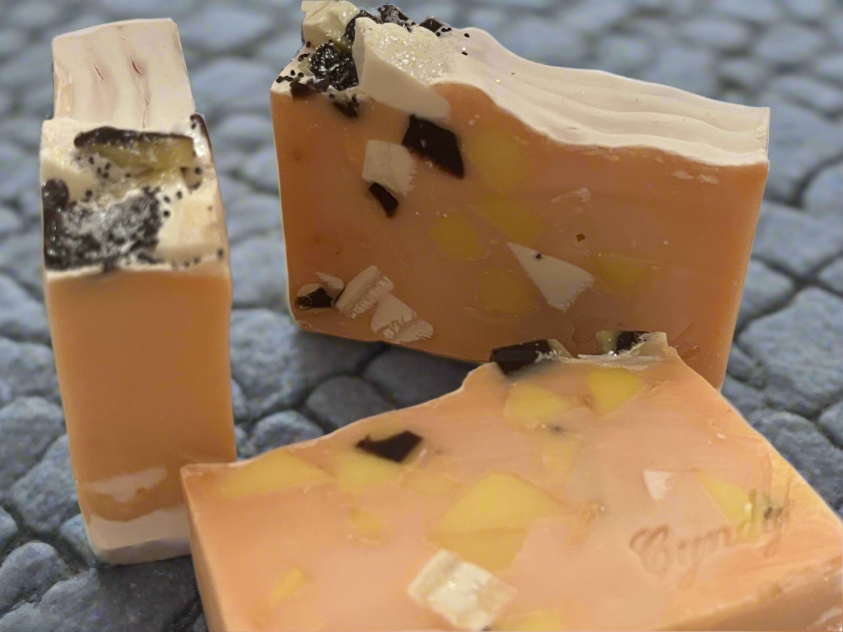 Three bars of soap with a cookie dough and chocolate chip design on a textured surface.